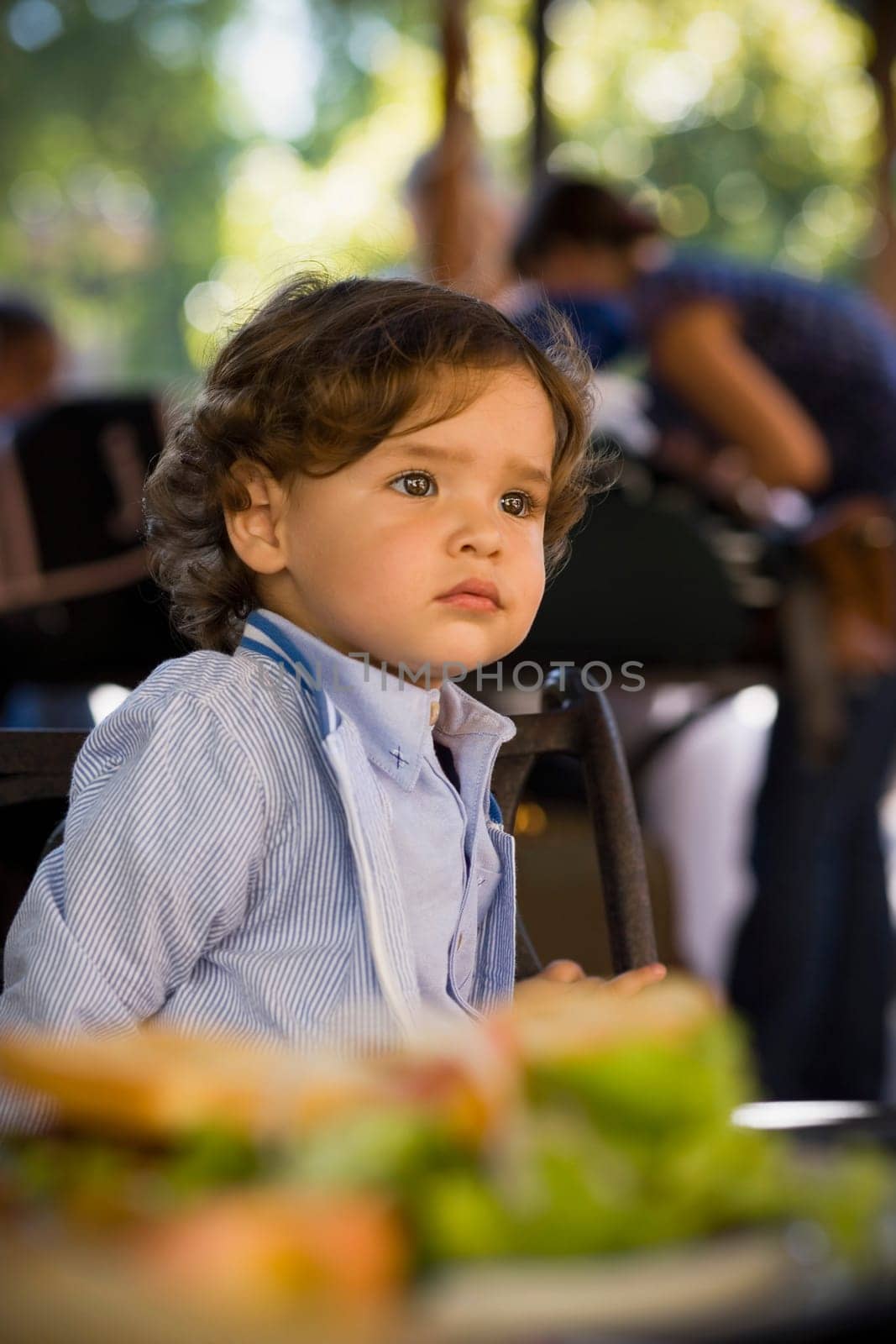 Close-up of a baby boy sitting at a table in a restaurant