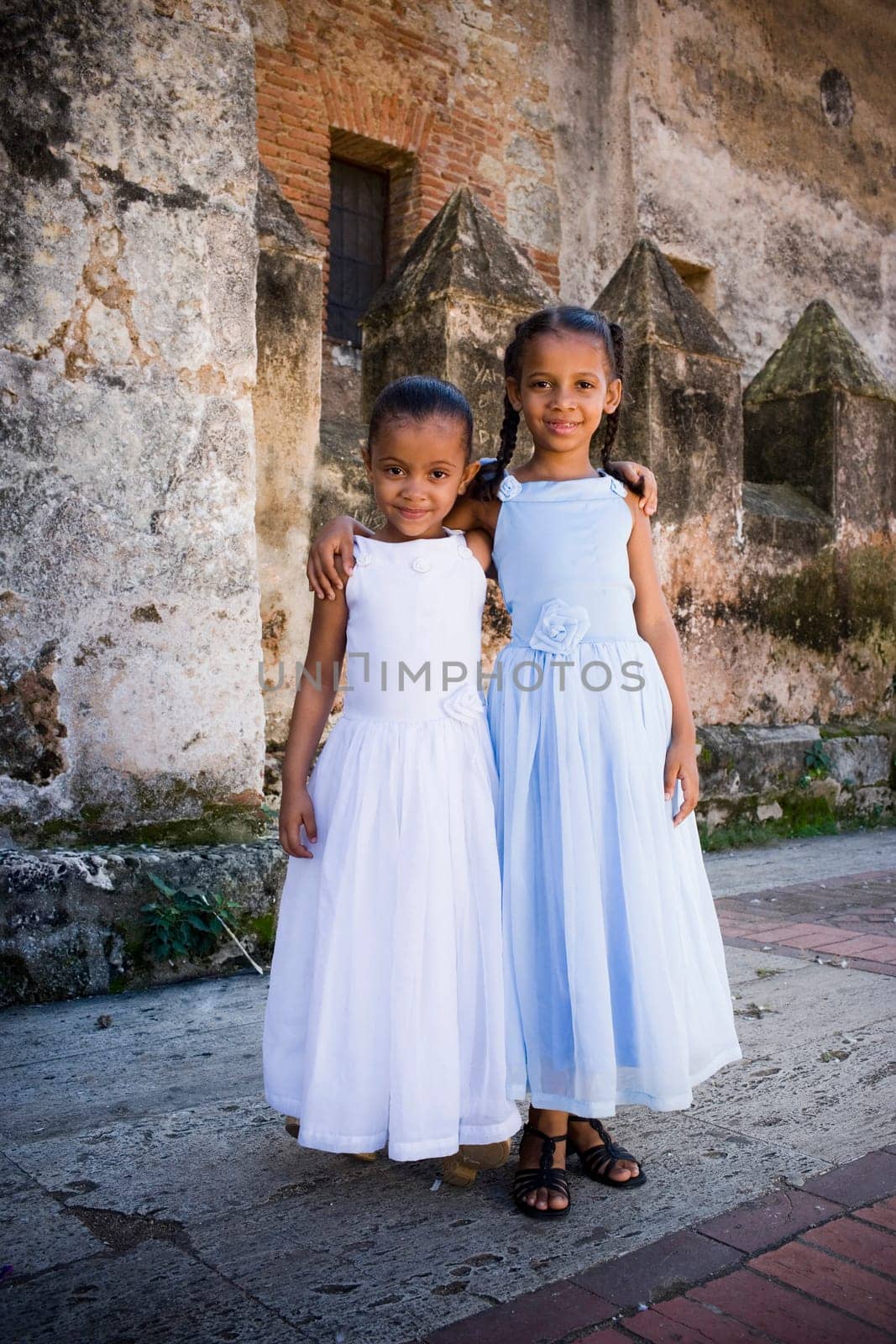 Portrait of two girls smiling and standing together with their arms around each other, Santo Domingo, Dominican Republic