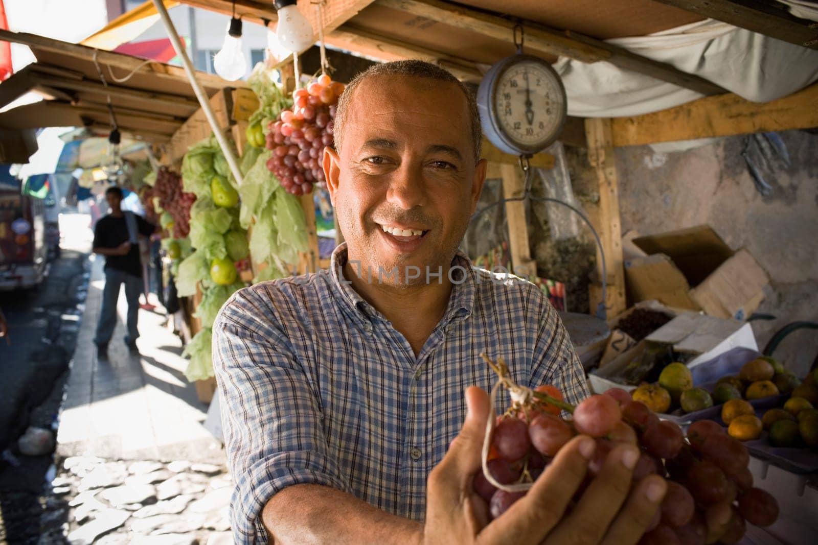 Portrait of a mature man holding a bunch of red grapes, Santo Domingo, Dominican Republic