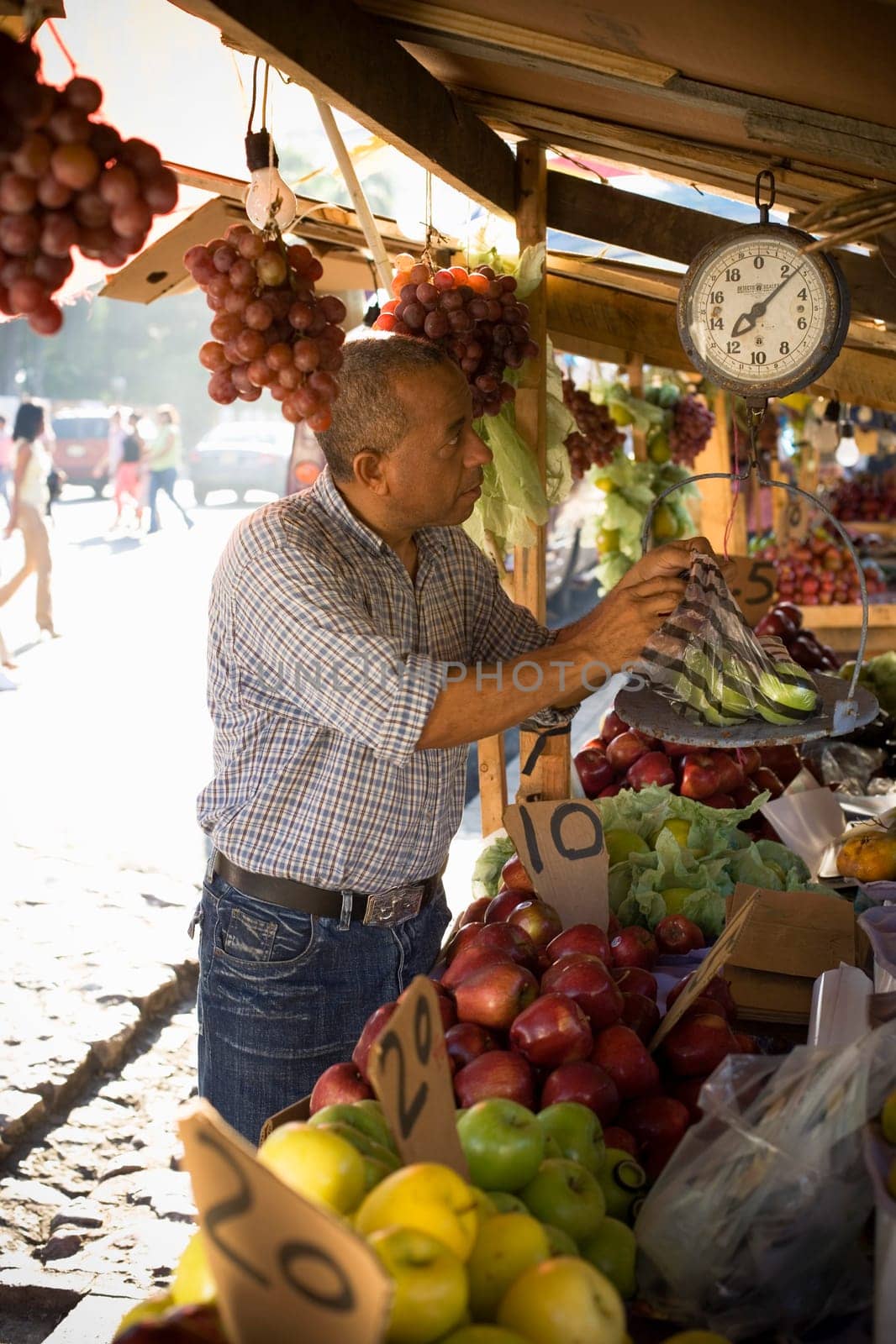 Side profile of a fruit seller weighing fruit, Santo Domingo, Dominican Republic