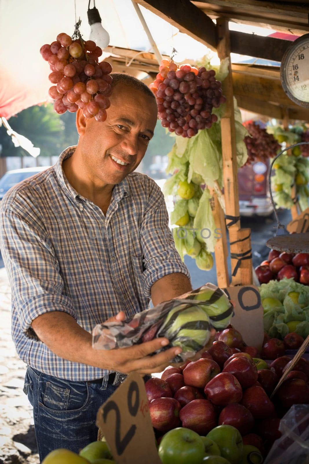 Portrait of a fruit seller holding apples in a plastic bag, Santo Domingo, Dominican Republic