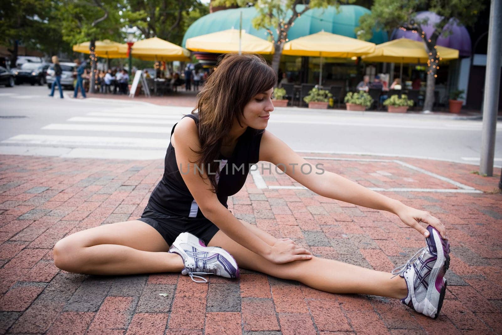 Young woman stretching with physical trainer