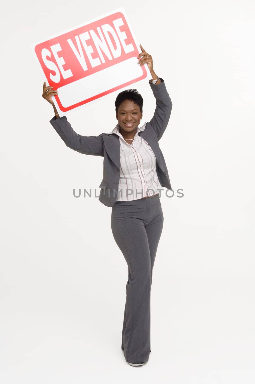Real Estate agent holding a For Sale (Se Vende) sign