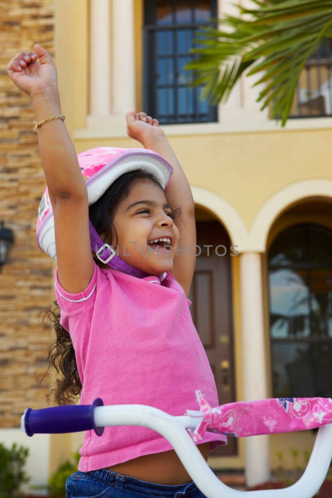 Close-up of a girl laughing with her arms raised