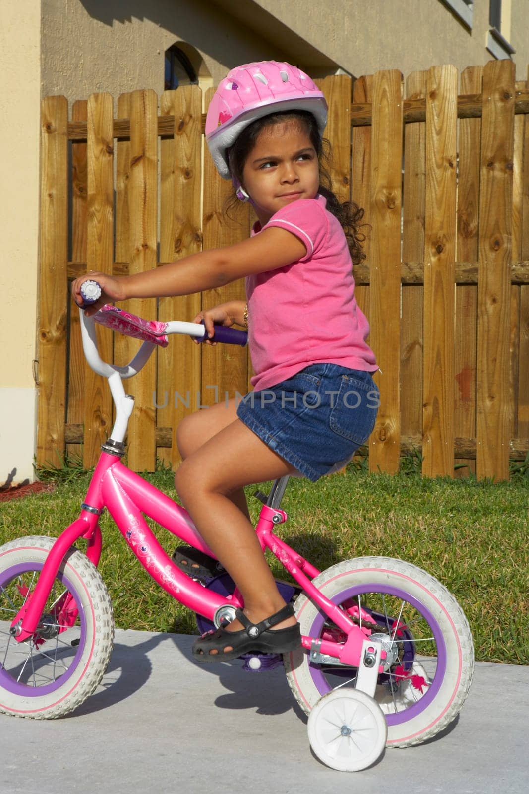 Side profile of a girl riding a bicycle on a path