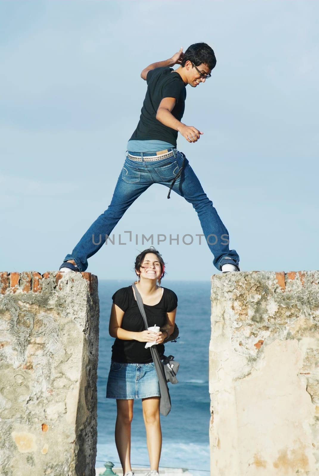 Young man jumping over girl