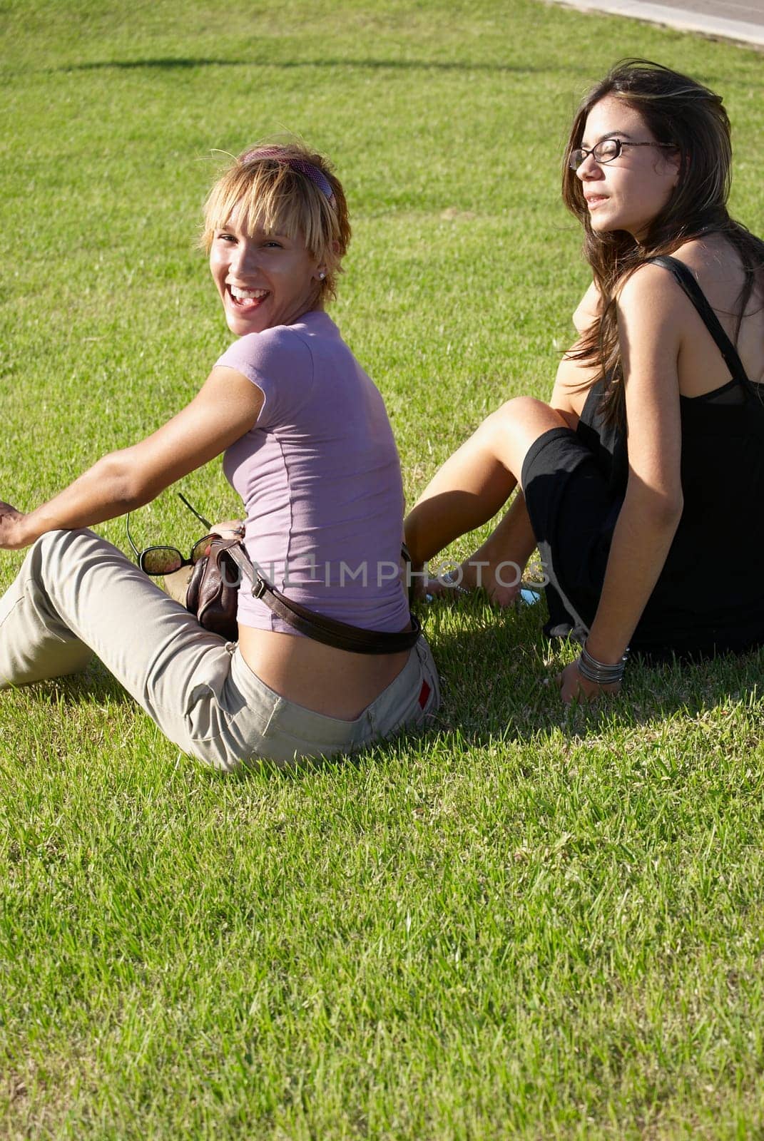 Friends sitting on grass in the sun