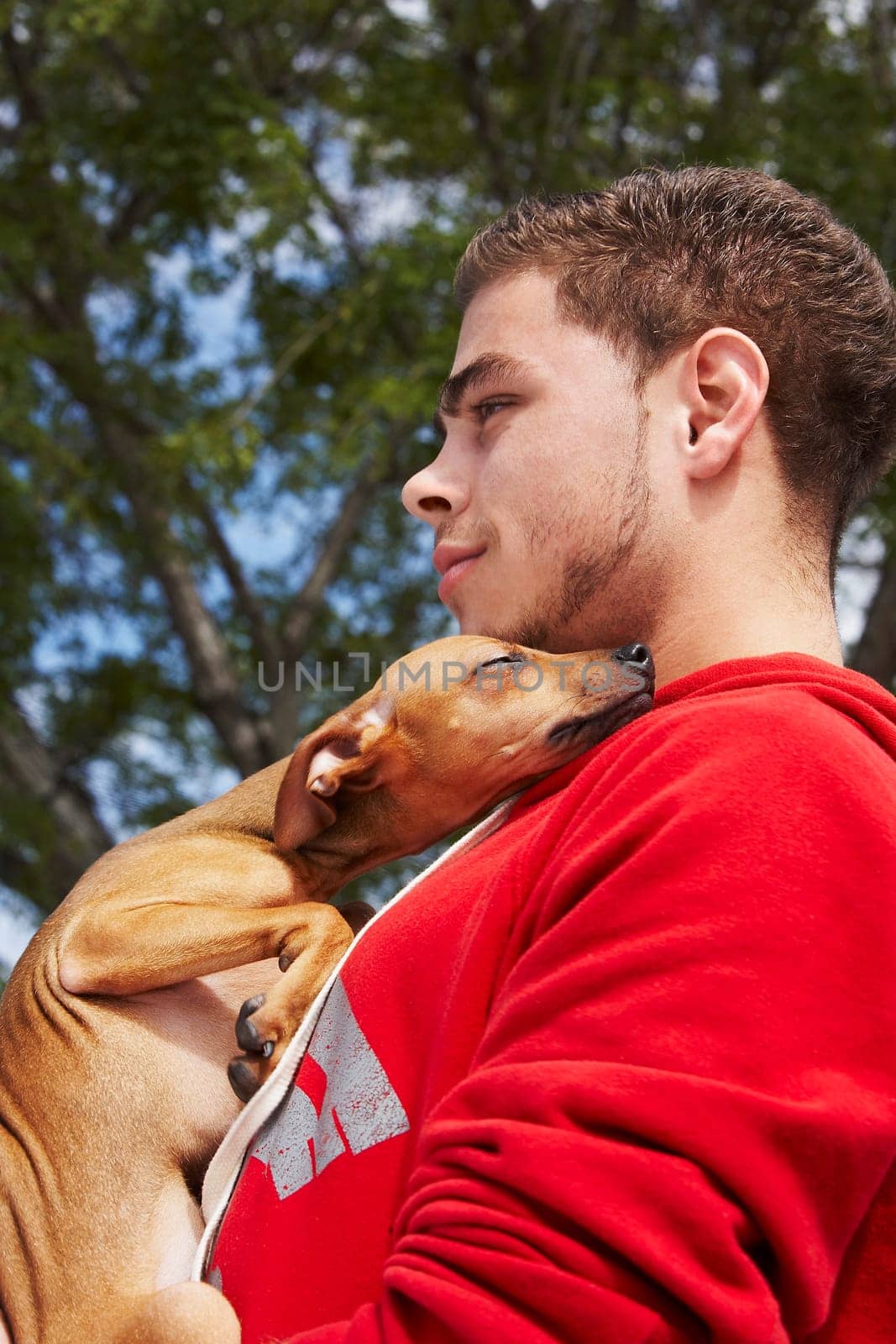 Side profile of a young man with a dog