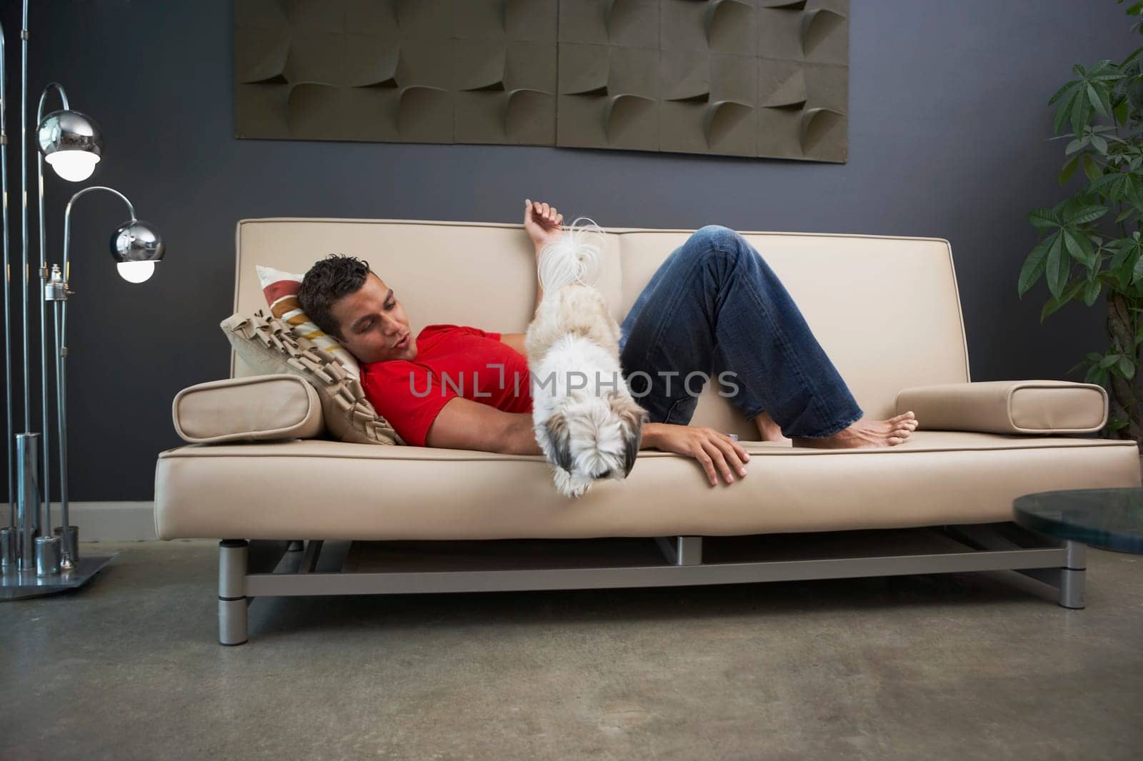 Side profile of a young man and a dog lying on a couch