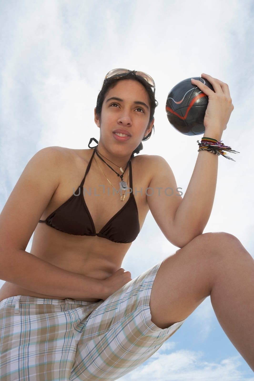 Low angle view of a young woman holding a soccer ball