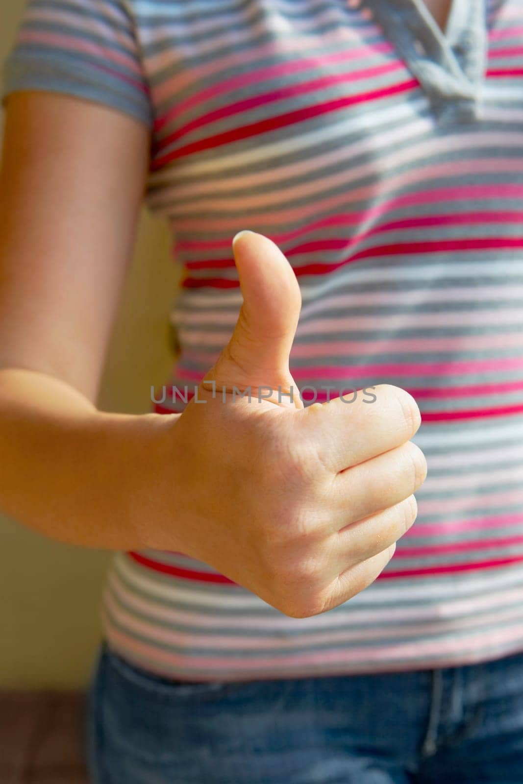 Mid section view of a woman making a thumbs up sign