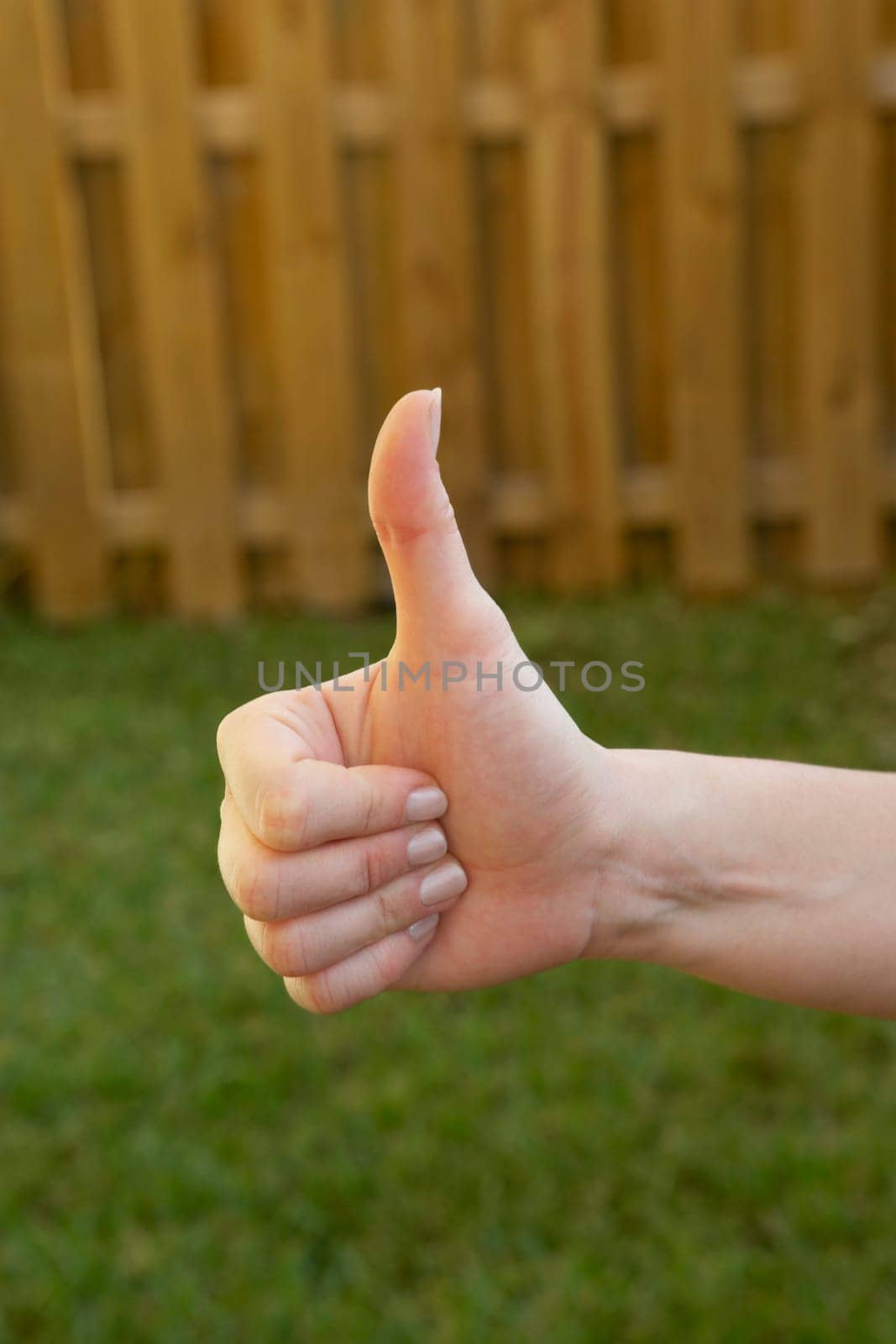 Close-up of a woman's hand making a thumbs up sign
