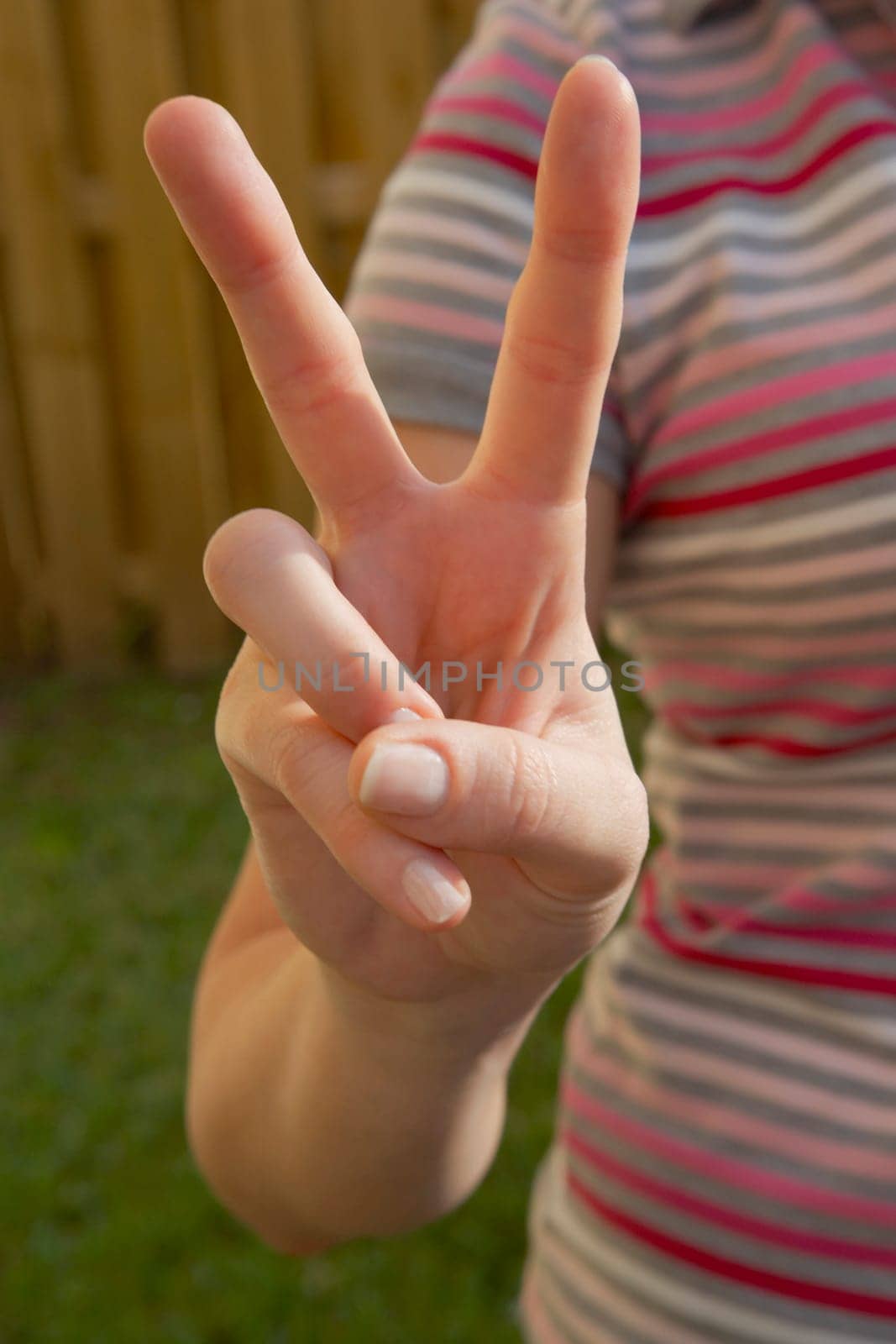 Mid section view of a woman making a peace sign