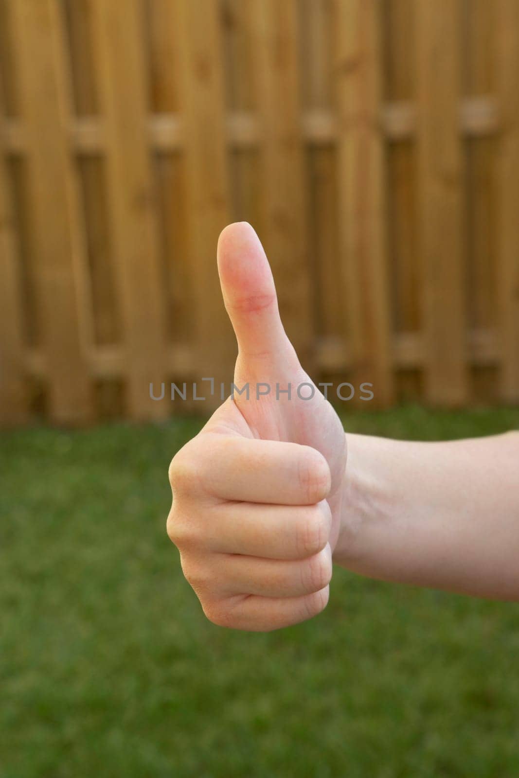 Close-up of a woman's hand making a thumbs up sign