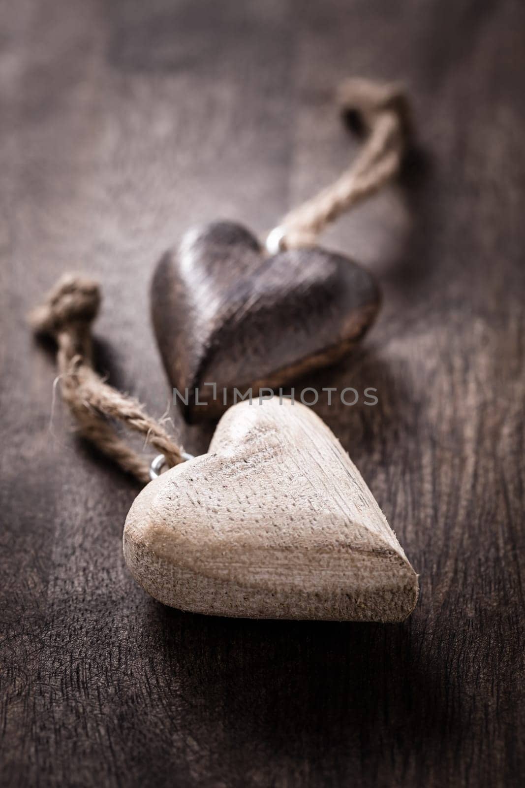 Black and white: two wooden hearts on wooden background