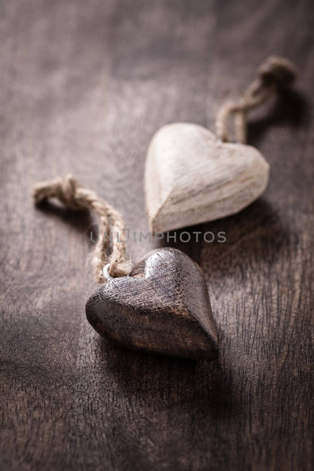 Black and white: two wooden hearts on wooden background