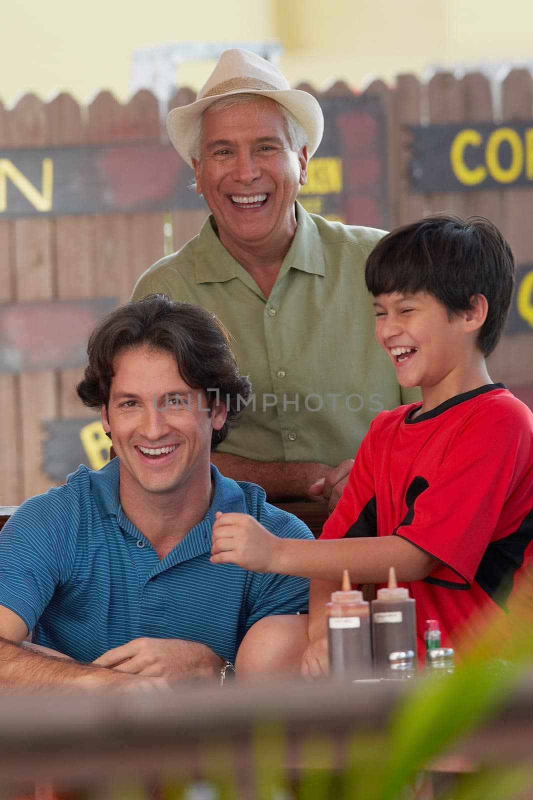 Portrait of a mid adult man smiling with his father and son in a restaurant