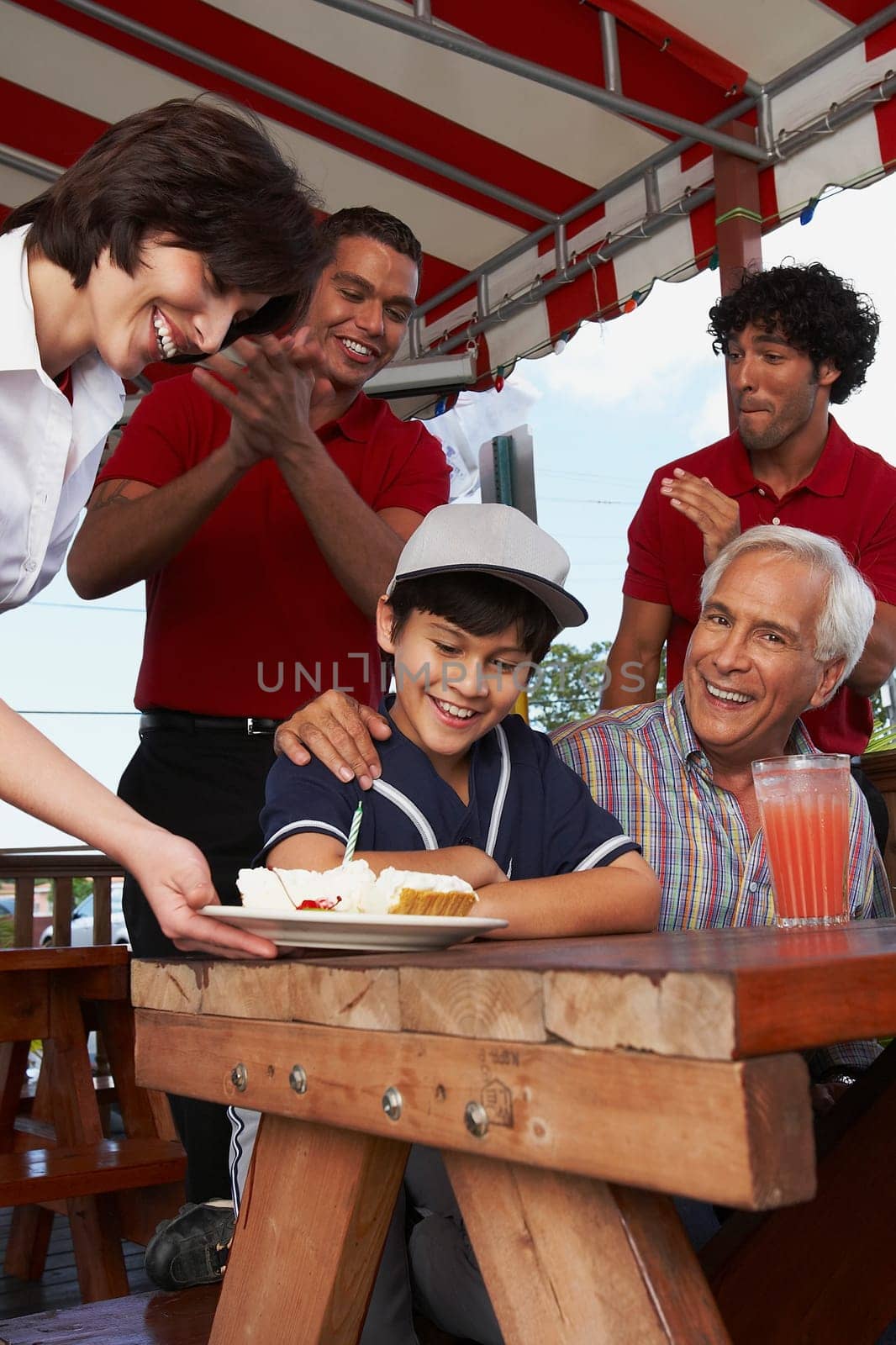 Portrait of a senior man celebrating his grandson's birthday in a restaurant