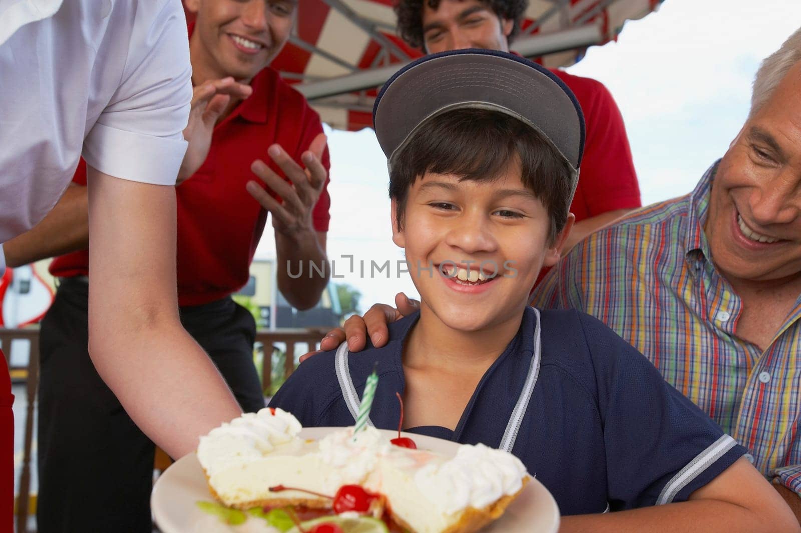 Portrait of a boy celebrating his birthday with his grandfather in a restaurant