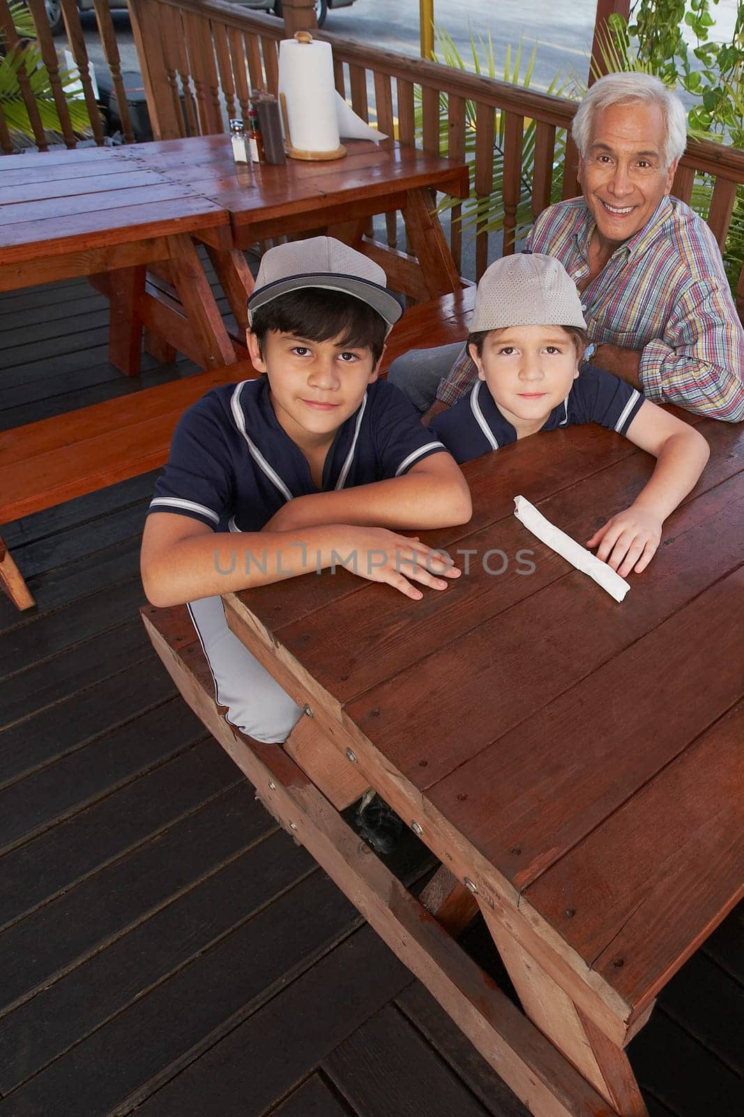 High angle view of a boy and a girl sitting with their grandfather in a restaurant