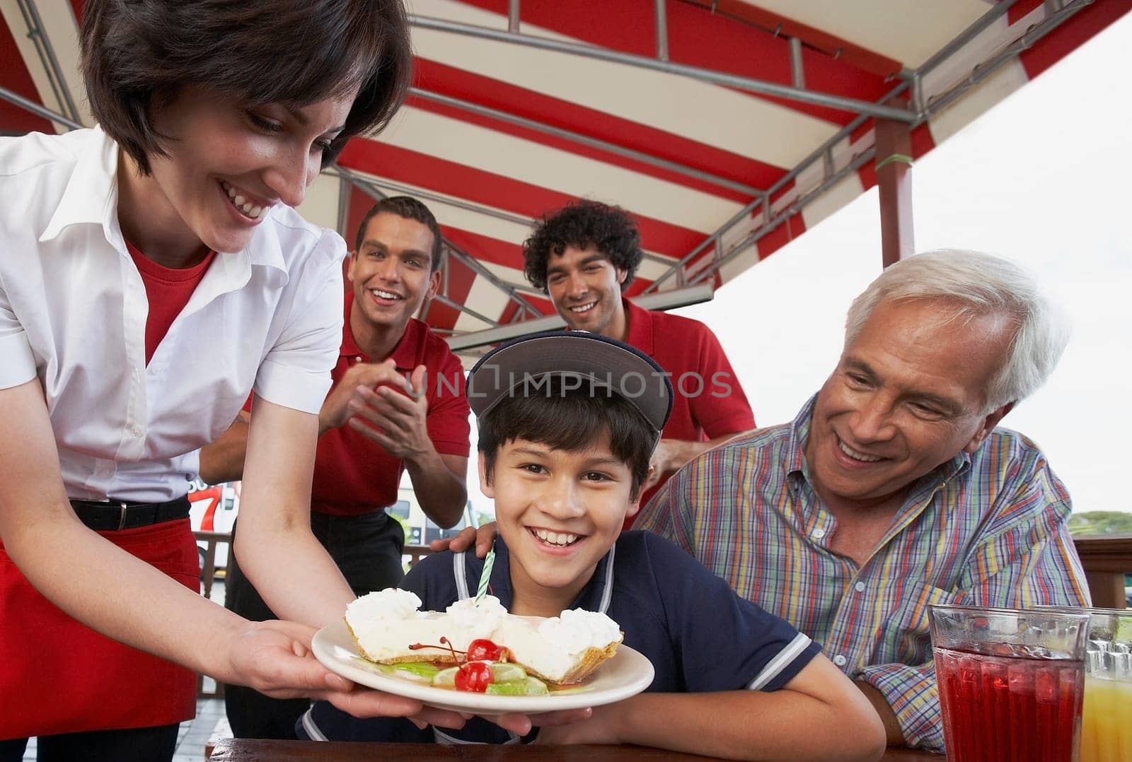 Portrait of a boy celebrating his birthday with his grandfather in a restaurant