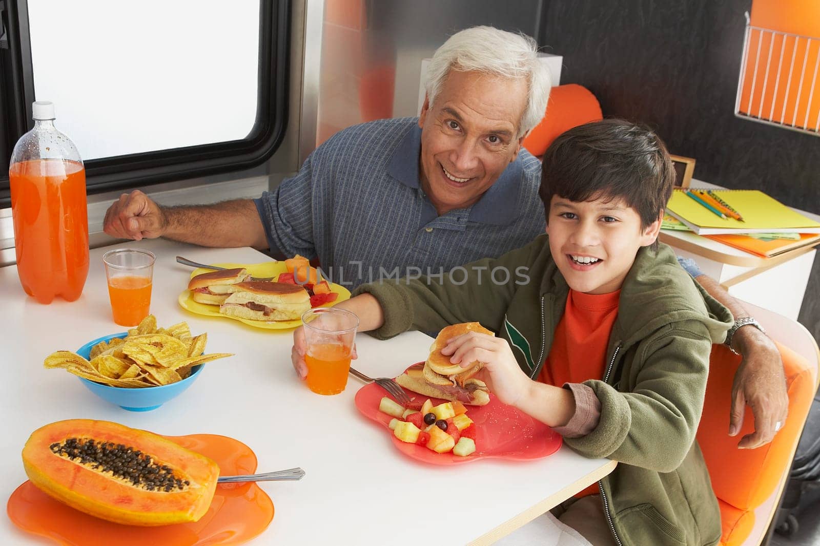 Senior man with his grandson having meal at the dining table