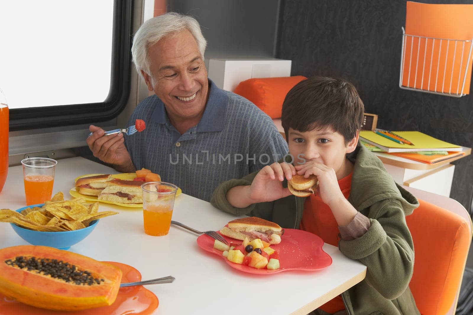 Senior man with his grandson having meal at the dining table