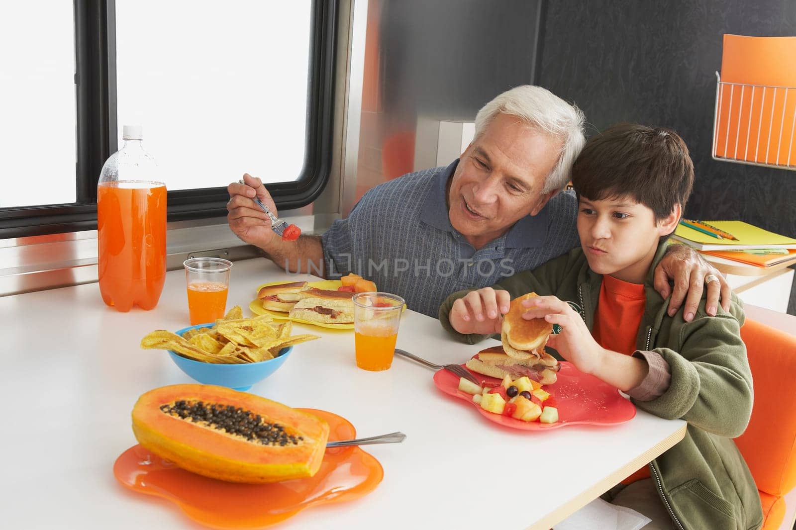 Senior man with his grandson having meal at the dining table