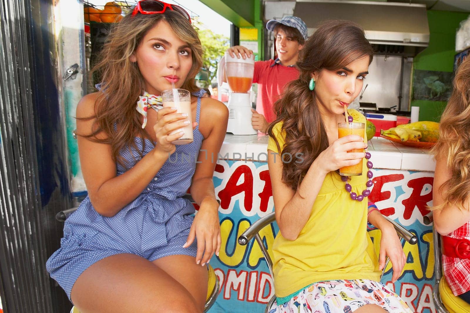 Close-up of a teenage girl drinking juice with her friends