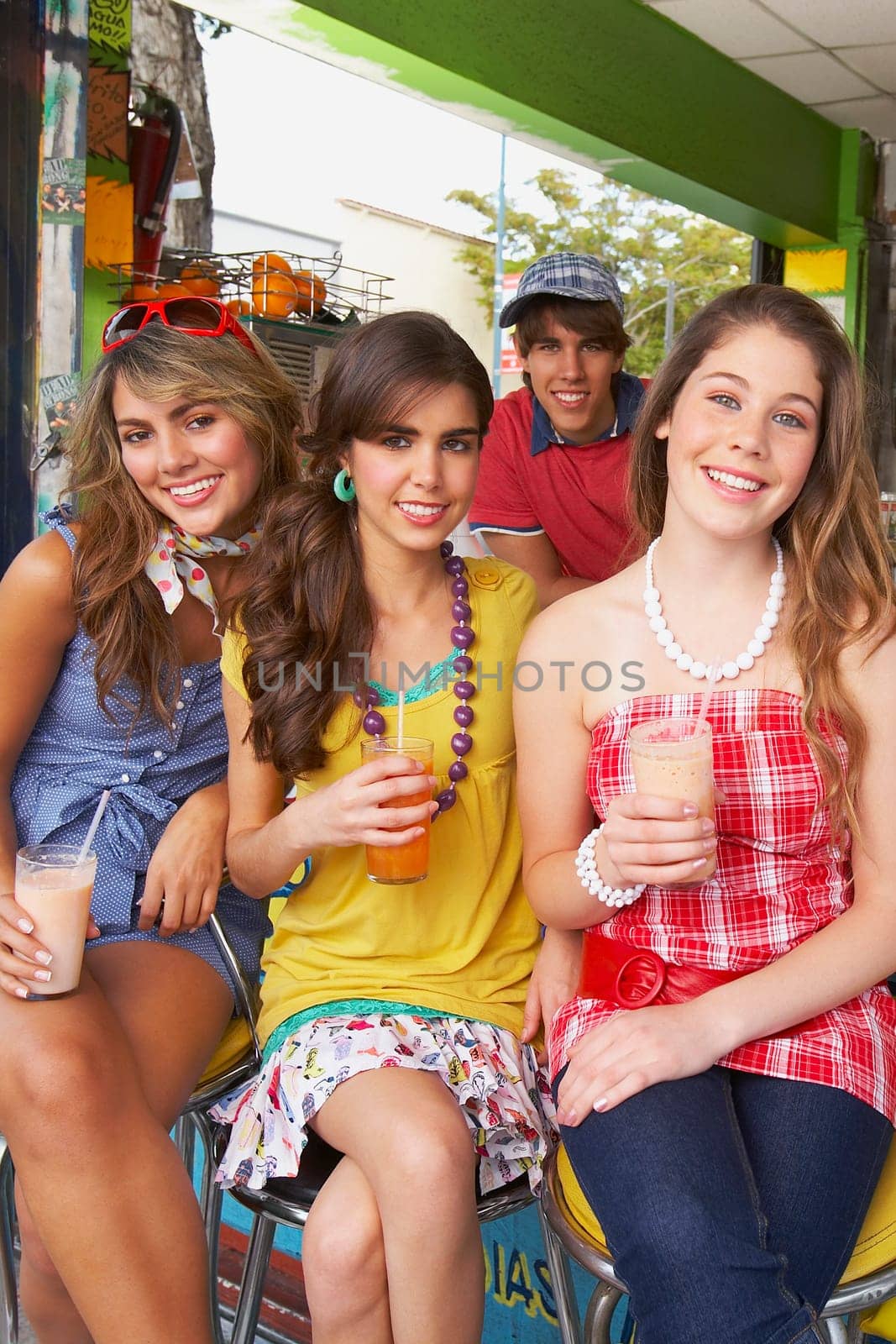Portrait of a teenage girl sitting with her friends at a juice bar