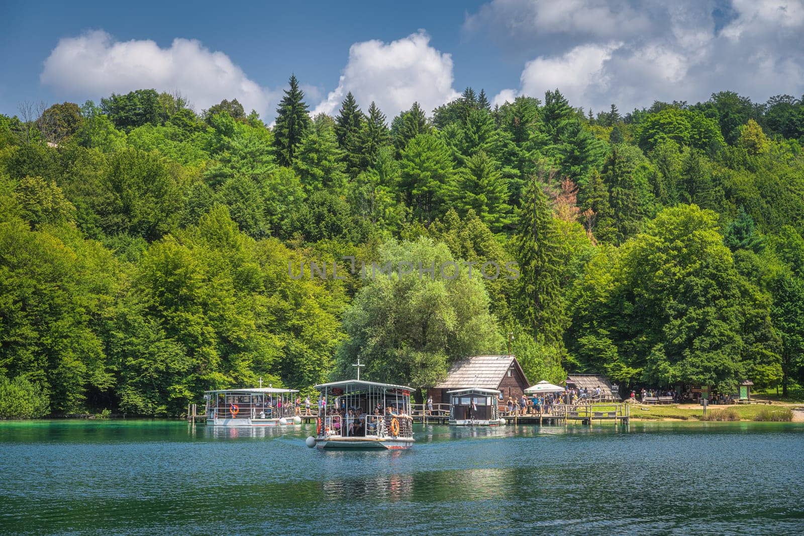Plitvicka Jezera, Croatia, July 2019 Ferry with tourists departing small harbour to cross the lake. Plitvice Lakes National Park UNESCO World Heritage