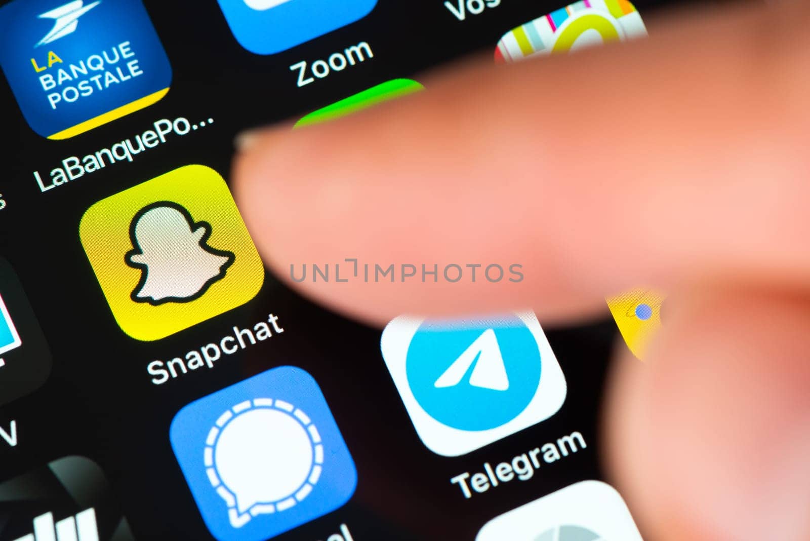 BAYONNE, FRANCE - CIRCA JANUARY 2021: Finger pointing at Snapchat app icon on Apple iPhone screen. Snapchat is a multimedia messaging app developed by Snap Inc.
