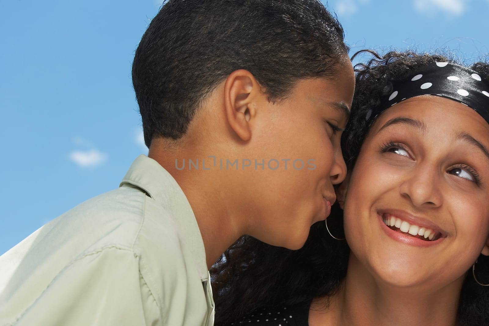 Side profile of a boy kissing a teenage girl