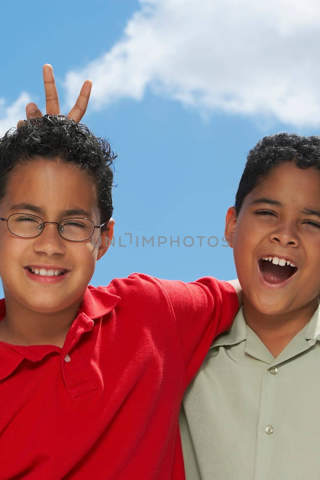 Portrait of a boy making a gesture of rabbit ears behind another boy's head