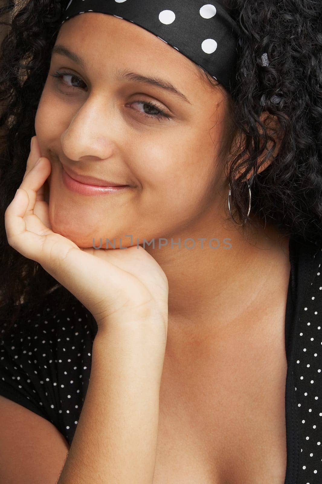Portrait of a teenage girl smiling with her hand on her chin