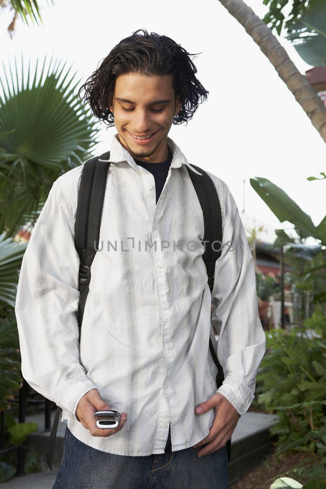 College student using a mobile phone and smiling