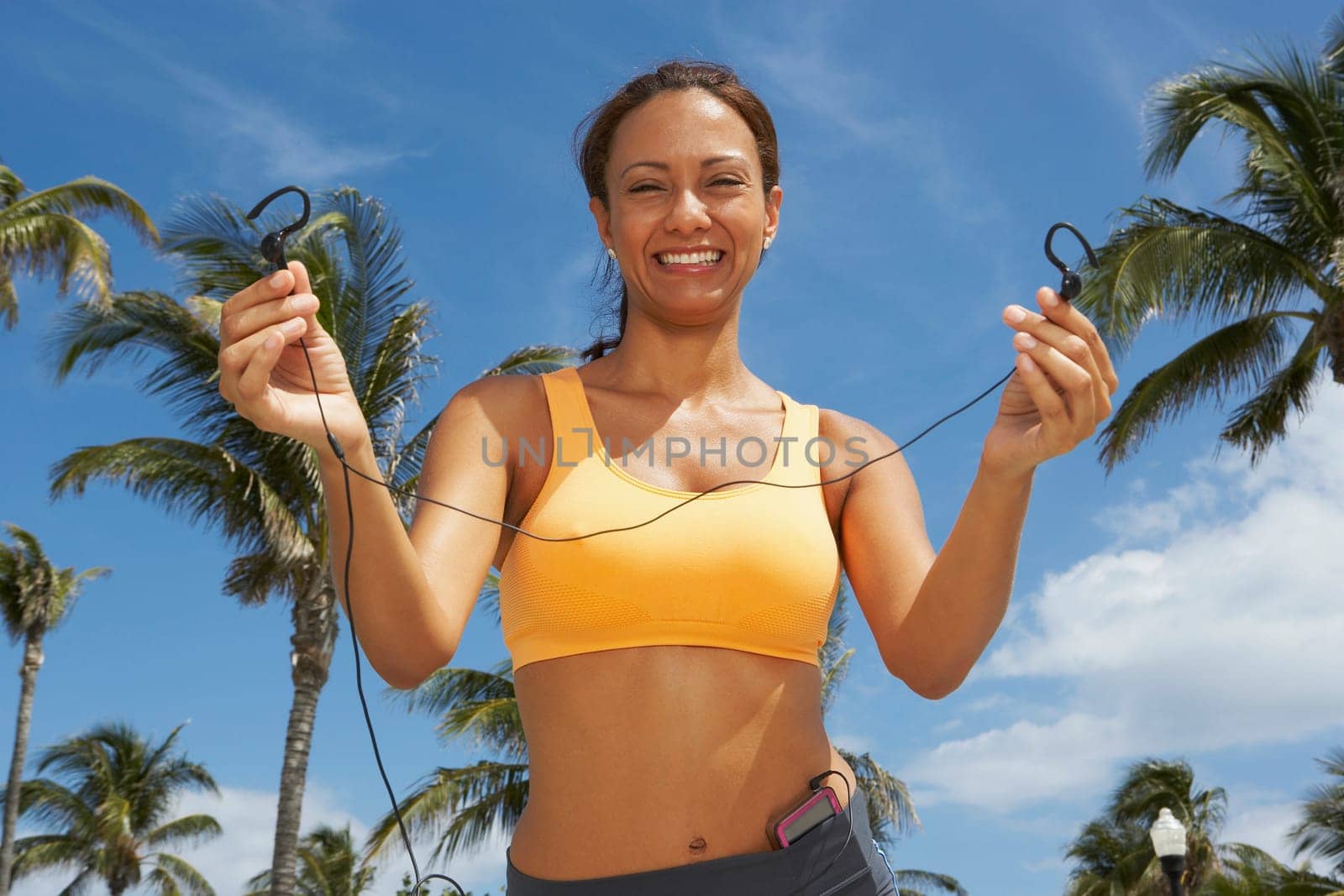Portrait of a mature woman offering her ear bud and smiling