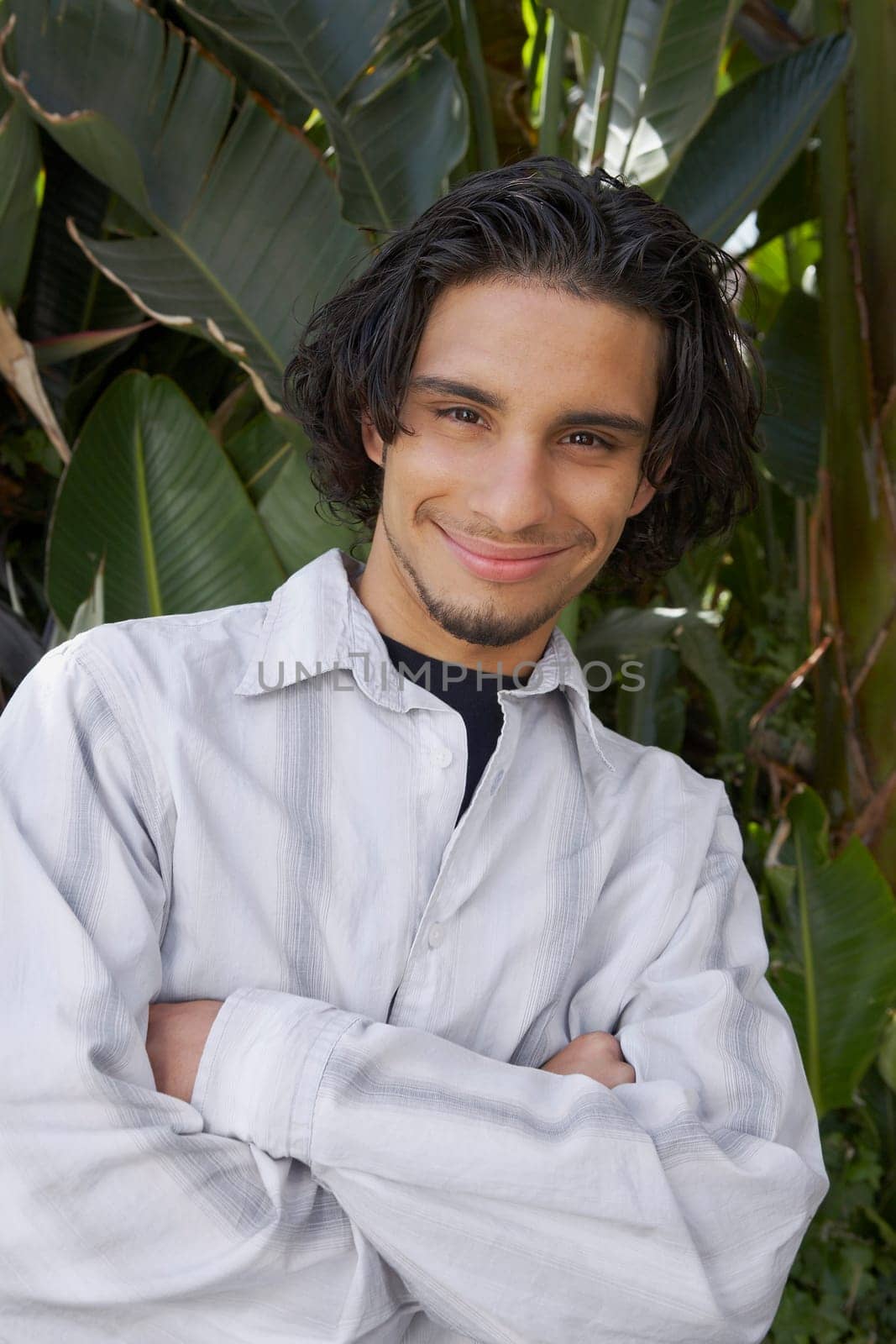 Portrait of a young man with his arms crossed and smiling