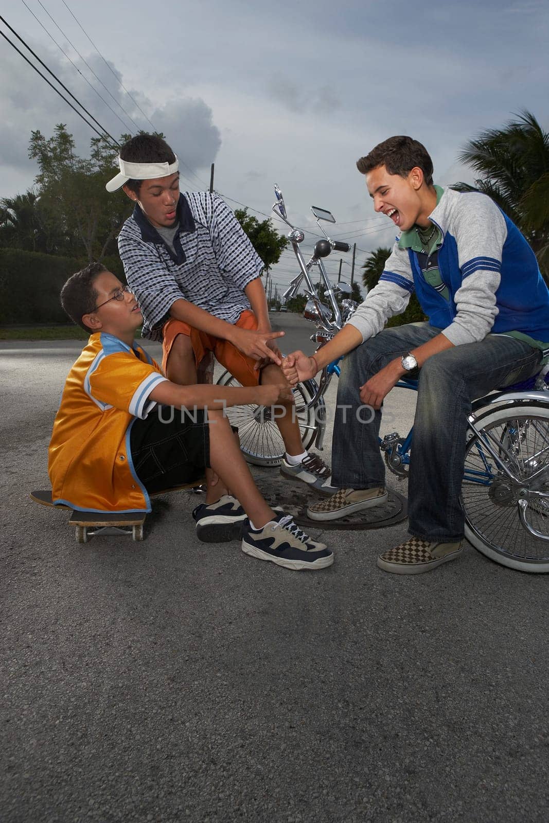 Teenage boy gesturing to his two friends and smiling