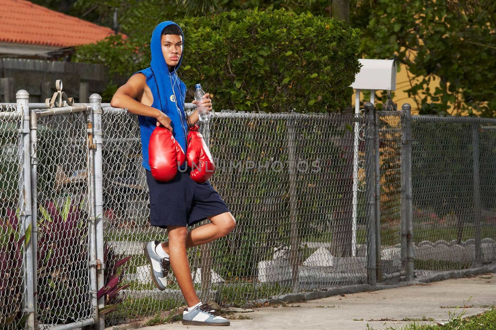 Side profile of a teenage boy listening an ipod and holding a bottle of water
