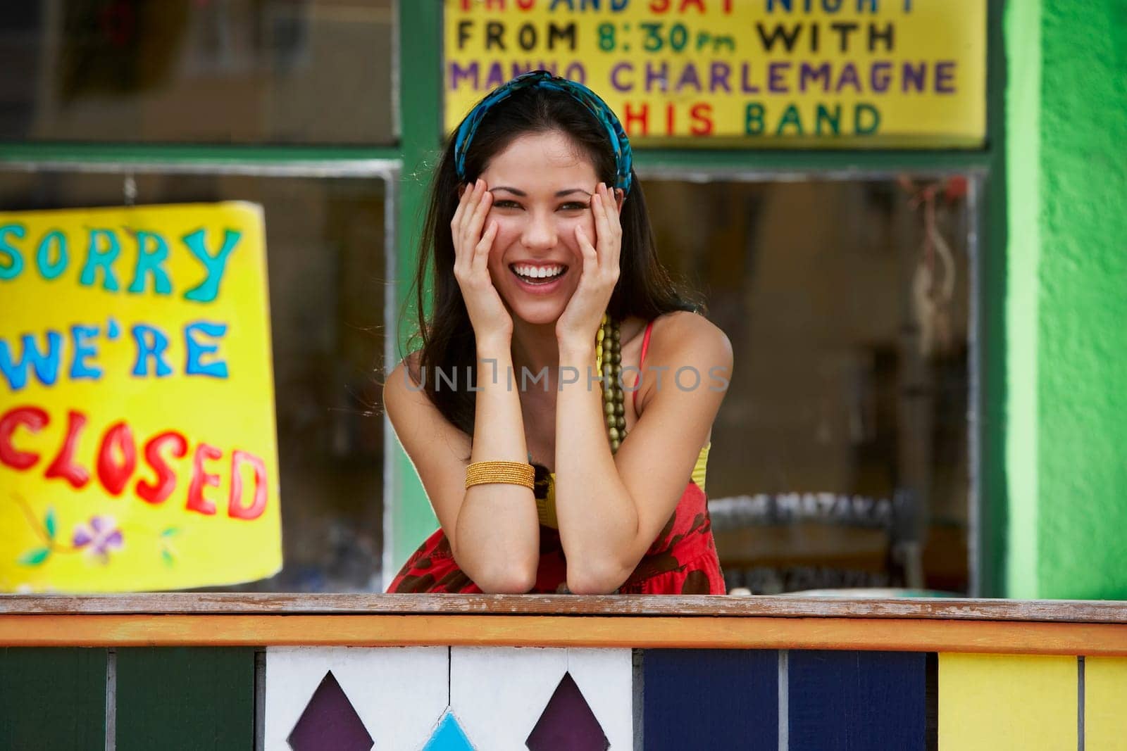Portrait of a young woman smiling and leaning on a railing