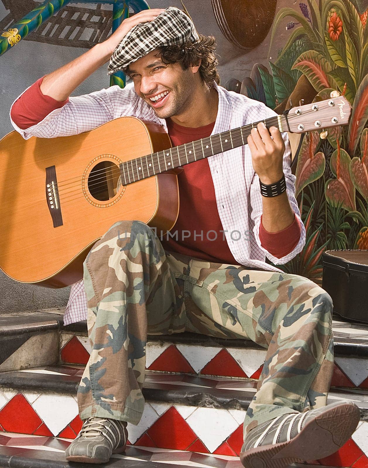 Portrait of a young man holding a guitar and smiling