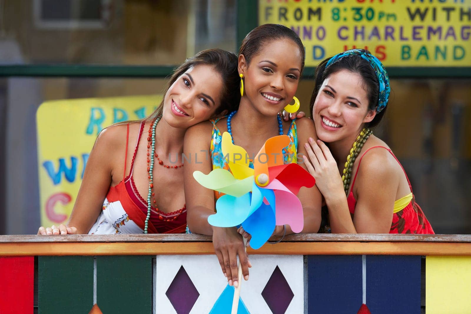 Portrait of three young women smiling and holding a pinwheel