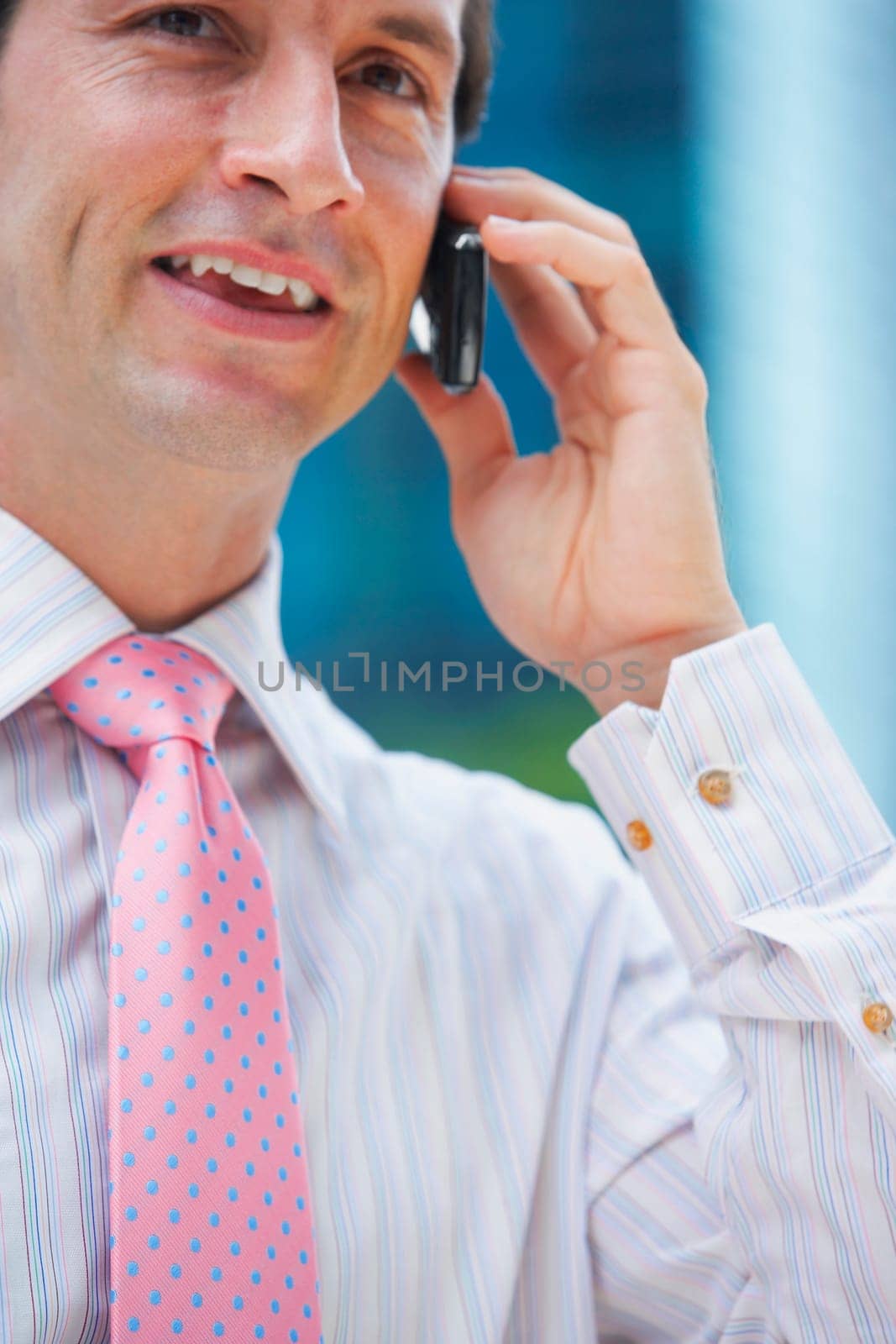 Mid section view of a businessman talking on a mobile phone