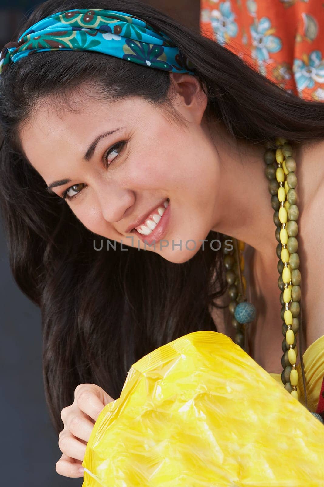 Portrait of a young woman holding a packet of potato chips