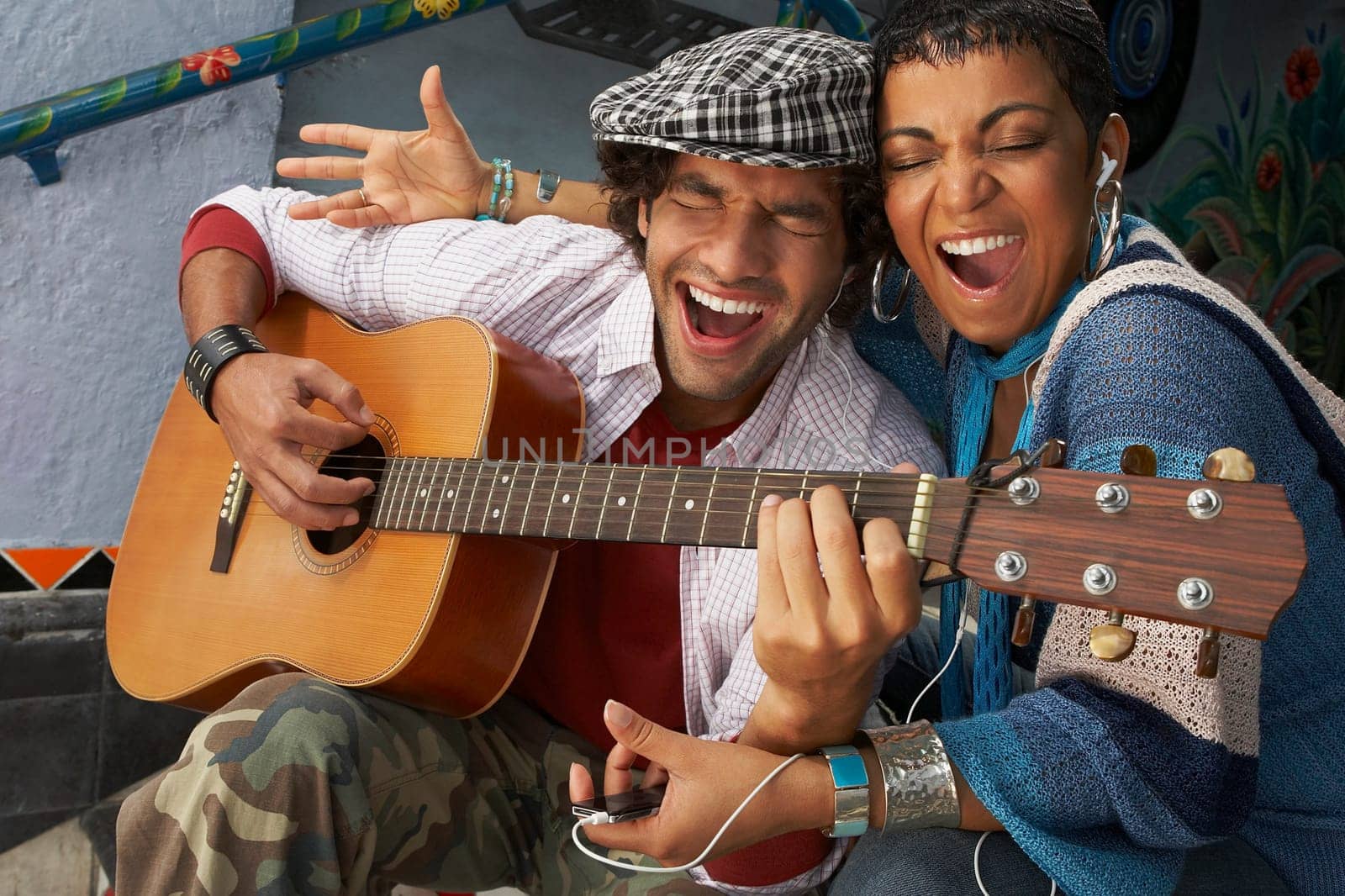 Close-up of a young man singing with a young woman and playing a guitar