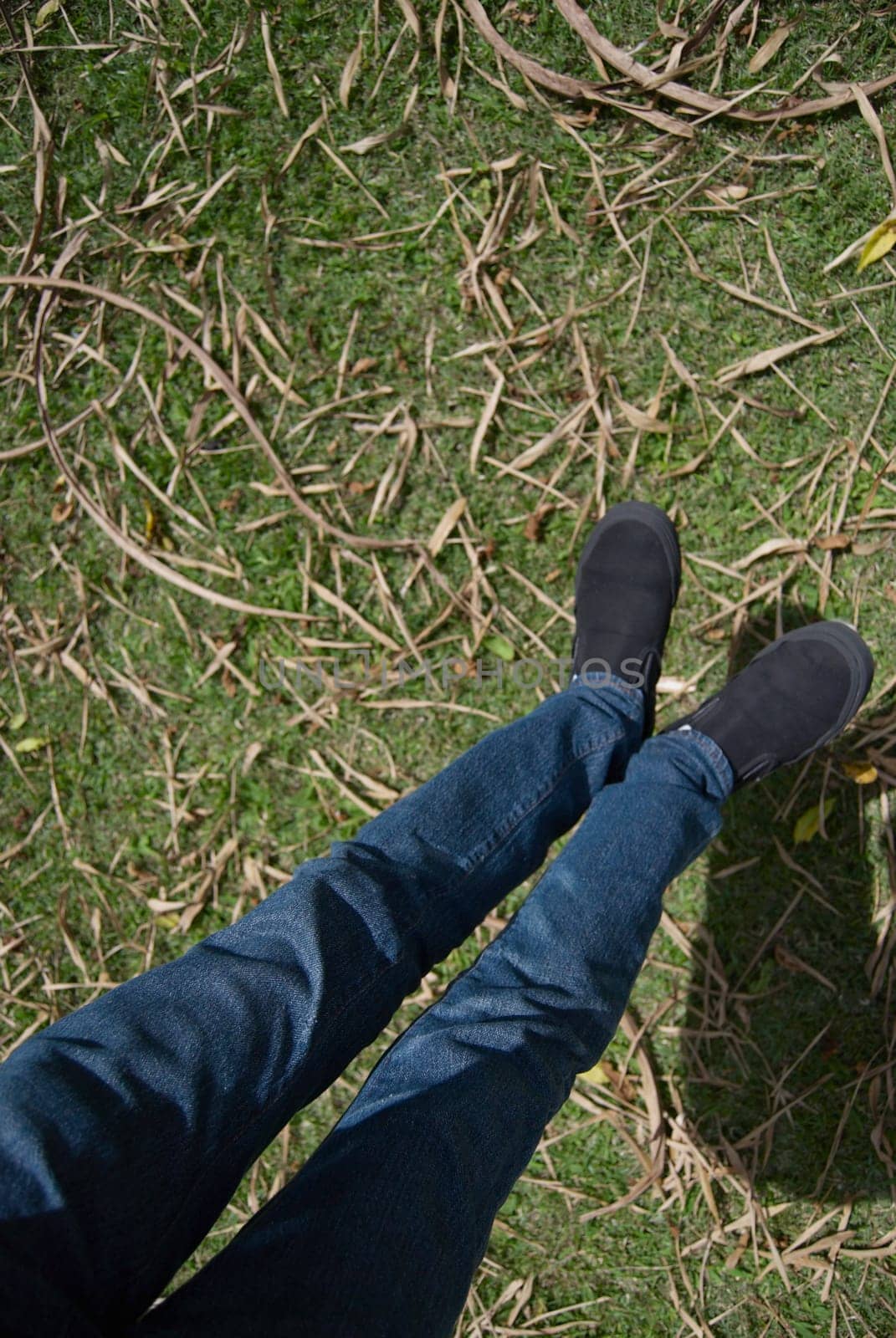 Low section view of a person's feet hanging over a lawn
