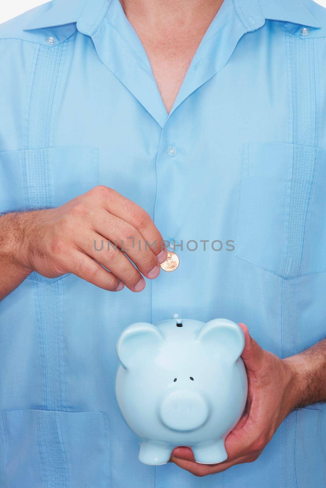 Mid section view of a male nurse inserting a gold coin into a piggy bank