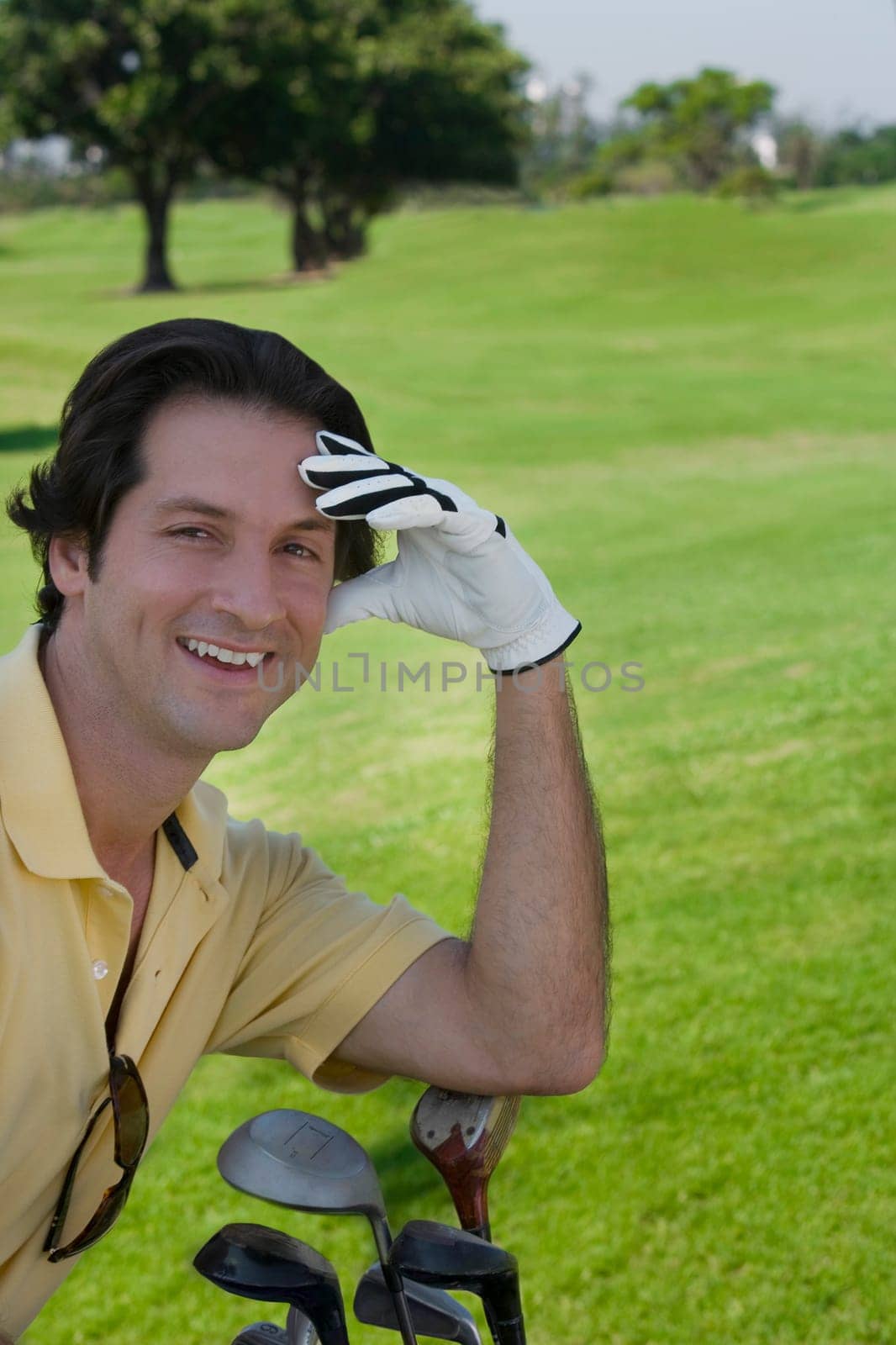 Portrait of a mid adult man smiling with golf clubs