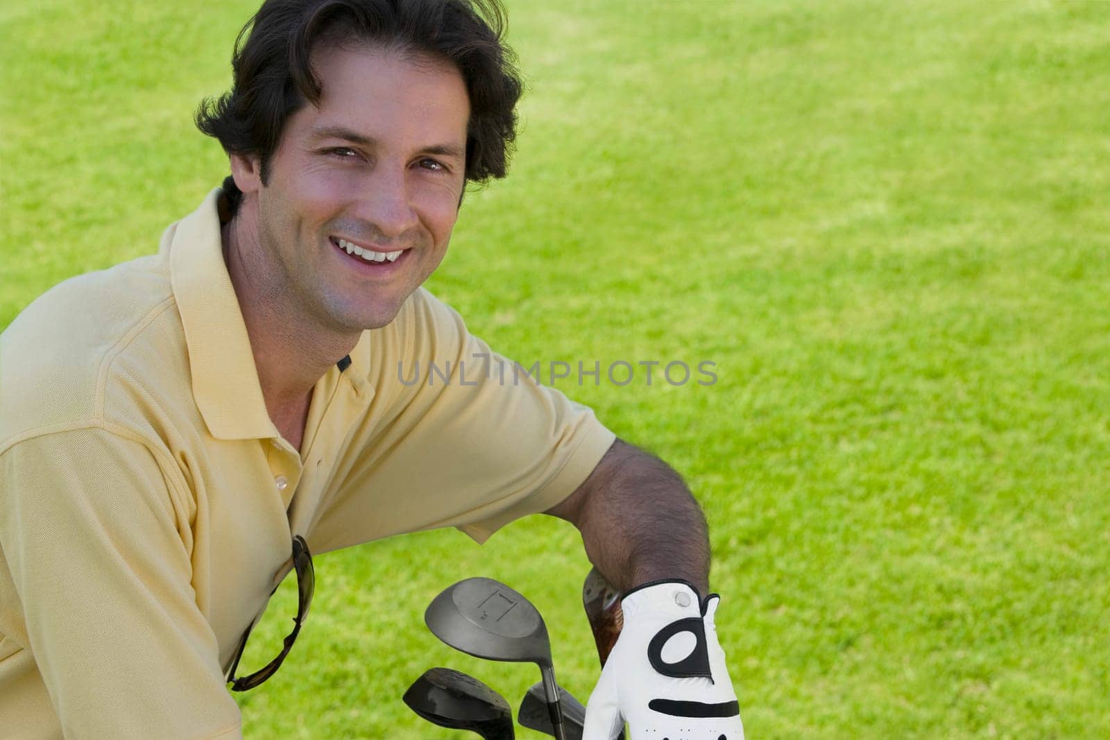 Portrait of a mid adult man smiling with golf clubs